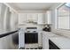 Practical kitchen featuring white cabinetry, black appliances, and checkered flooring at 892 Summer Dr # 15B, Highlands Ranch, CO 80126