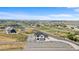 Expansive aerial view of a two-story home on acreage with mountain views and white vinyl fencing at 16197 Paris Way, Brighton, CO 80602