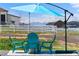 Backyard seating area with mountain views, umbrella, and Adirondack chairs at 16197 Paris Way, Brighton, CO 80602