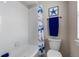 Cozy bathroom featuring a combination shower and tub, with tiled walls and beach-themed decor at 16197 Paris Way, Brighton, CO 80602