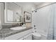 Clean bathroom with white tile, granite counters, and a shower-tub combination at 16197 Paris Way, Brighton, CO 80602