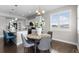 A dining area complemented by an eat-in kitchen island, with sunlit windows at 16197 Paris Way, Brighton, CO 80602