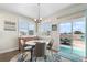 Charming dining room featuring a modern chandelier, hardwood floors, and access to the backyard at 16197 Paris Way, Brighton, CO 80602