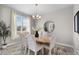 Elegant dining room featuring a decorative chandelier, large window and marble table at 16197 Paris Way, Brighton, CO 80602