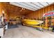 Wood paneled garage featuring a boat and motorcycle at 16197 Paris Way, Brighton, CO 80602