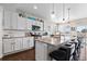 Gourmet kitchen featuring granite countertops, white cabinets, stainless steel appliances, and a large island with bar seating at 16197 Paris Way, Brighton, CO 80602