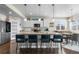 Gourmet kitchen featuring granite countertops, white cabinets, stainless steel appliances, and a large island with bar seating at 16197 Paris Way, Brighton, CO 80602