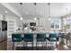 Bright kitchen featuring a large island with seating, pendant lighting, and stainless steel appliances at 16197 Paris Way, Brighton, CO 80602