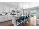 Spacious kitchen showcasing an eat-in island, white cabinetry, granite countertops and stainless steel appliances at 16197 Paris Way, Brighton, CO 80602