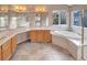 Bathroom featuring tile floors, a jacuzzi tub and dual sinks with wood cabinets at 10645 Clarkeville Way, Parker, CO 80134