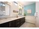 Modern bathroom features double sinks, dark cabinets, tub, and ample counter space at 5050 Akron St, Denver, CO 80238