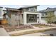 Modern home exterior with a covered porch and well-maintained yard, showcasing its contemporary design at 5050 Akron St, Denver, CO 80238