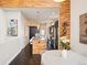 Open-concept kitchen with island, pendant lighting, stainless steel appliances, and wood-paneled accent wall at 5050 Akron St, Denver, CO 80238