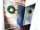 Unique rustic wood wall with a decorative wreath and open doorway at 15468 W 50Th Pl, Golden, CO 80403
