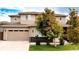 Two-story home with a two car garage, neutral color scheme, and landscaped front yard with healthy trees at 15468 W 50Th Pl, Golden, CO 80403