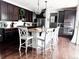 Modern kitchen with dark wood cabinets, granite countertops, stainless appliances, and bar seating at 15468 W 50Th Pl, Golden, CO 80403