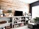 Inviting living room features a wood accent wall with open shelving and modern decor at 15468 W 50Th Pl, Golden, CO 80403