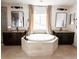 Luxurious main bathroom showcasing a soaking tub, granite counters, and dual sinks at 15468 W 50Th Pl, Golden, CO 80403