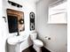 Chic powder room with modern fixtures, decorative mirror, and natural light at 15468 W 50Th Pl, Golden, CO 80403