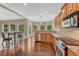 Open-concept kitchen with stainless steel appliances, granite counters, and breakfast bar seating with hardwood floors at 7170 Windwood Way, Parker, CO 80134