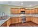 Well-equipped kitchen features wooden cabinetry, stainless steel appliances, and granite countertops at 7170 Windwood Way, Parker, CO 80134