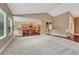 Living room featuring plush carpet, an open layout, and natural lighting with kitchen view at 7170 Windwood Way, Parker, CO 80134