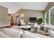 Bright living room features a plush sectional sofa, modern decor, and an abundance of natural light at 7170 Windwood Way, Parker, CO 80134