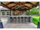 Outdoor kitchen and bar area with seating for six and decorative lighting at 7170 Windwood Way, Parker, CO 80134