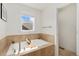 Soaking tub features tile surround and a window that offers ample natural light at 2856 Shadow Lake Rd, Lafayette, CO 80026
