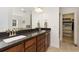 Bathroom features dual sinks with dark granite countertops and a walk in closet with custom shelving at 2856 Shadow Lake Rd, Lafayette, CO 80026