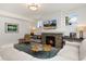 Relaxing living room features a stone fireplace, TV, comfortable seating, and lots of natural light at 2856 Shadow Lake Rd, Lafayette, CO 80026