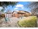 Expansive backyard view featuring a shed, patio, seating area, and mature trees at 9720 W Kentucky Dr, Lakewood, CO 80226