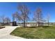 Community baseball field with red clay, covered benches, green outfield, and mature trees at 9720 W Kentucky Dr, Lakewood, CO 80226