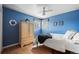 Blue bedroom with hardwood floors featuring a window and natural wood armoire at 9720 W Kentucky Dr, Lakewood, CO 80226