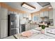 Inviting kitchen with stainless steel appliances, white cabinets and view of the dining area at 9720 W Kentucky Dr, Lakewood, CO 80226