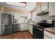 Well-lit kitchen with stainless steel appliances, white cabinets, and neutral countertops at 9720 W Kentucky Dr, Lakewood, CO 80226