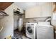 Functional laundry room with washer, dryer, water heater, and storage cabinets at 9720 W Kentucky Dr, Lakewood, CO 80226