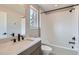 Modern bathroom features a shower-over-tub, tile accents, and a sleek vanity with stone countertop and black hardware at 3420 N Steele St, Denver, CO 80205