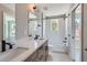 Spa-like bathroom with dual sinks, quartz countertops, a soaking tub, and tiled shower at 3420 N Steele St, Denver, CO 80205