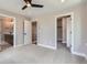 Inviting bedroom showcasing carpet, ceiling fan, and en-suite access to bathroom, staircase, and wardrobe at 3420 N Steele St, Denver, CO 80205
