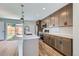 Beautiful kitchen featuring stainless appliances, white backsplash, dark cabinets, and modern fixtures at 3420 N Steele St, Denver, CO 80205