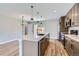 Well-lit kitchen boasts modern stainless steel appliances, quartz countertops and an island with pendant lighting at 3420 N Steele St, Denver, CO 80205