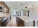 Modern kitchen features stainless appliances, quartz counters, dark cabinets, and island with pendant lighting at 3420 N Steele St, Denver, CO 80205