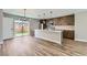Open-concept kitchen featuring stainless steel appliances, a large island with pendant lights, and backyard access at 3420 N Steele St, Denver, CO 80205