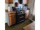 Traditional kitchen featuring a modern black gas range and wooden cabinets at 150 Fulton Ave, Fort Lupton, CO 80621