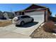 Front exterior showcasing a home with an attached garage and paved driveway at 2003 Monte Vista Dr, Lochbuie, CO 80603