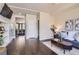 Bright and open living room with hardwood floors, a view into the kitchen and modern shelving at 2700 E Louisiana Ave # 203, Denver, CO 80210