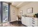 Bright office space featuring dark wood floors, a built-in desk, and a balcony door at 2700 E Louisiana Ave # 203, Denver, CO 80210