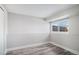 Basement room featuring wood-look floors, a large window, and neutral wall color scheme at 3738 Rosewalk Ct, Highlands Ranch, CO 80129
