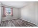 Cozy bedroom with wood-look floors, a large window, and neutral wall color scheme at 3738 Rosewalk Ct, Highlands Ranch, CO 80129